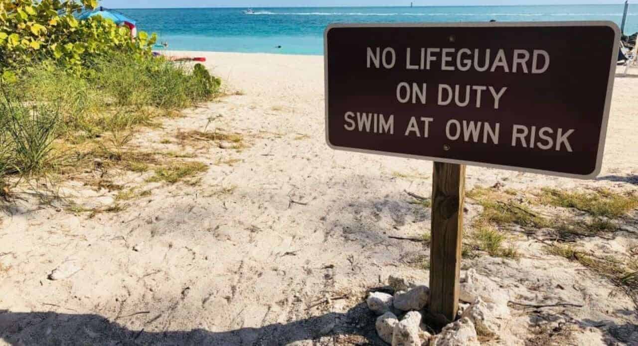 A sign on the beach that says no lifeguard on duty