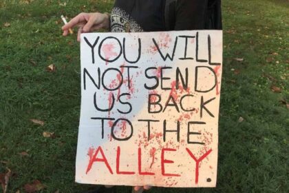 An abortion protest sign referencing women performing their own abortions when it wasn’t legal in the past.
