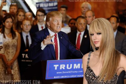 Donald Trump speaking at a podium making a grabbing gesture with Taylor Swift in the foreground