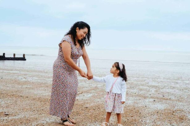 Mother and young daughter walking on the sand at the beach