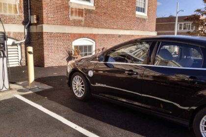 Electric vehicle parked at a charging station in a parking lot.