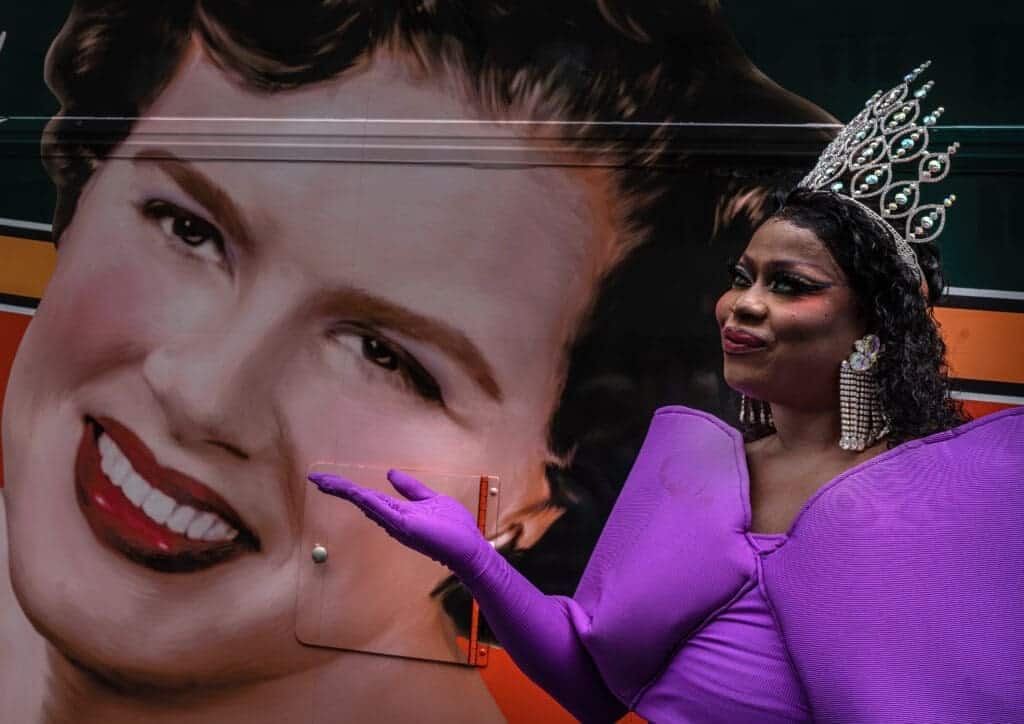 Miss nashville pride sasha dereon poses next a portrait of country music icon patsy cline.