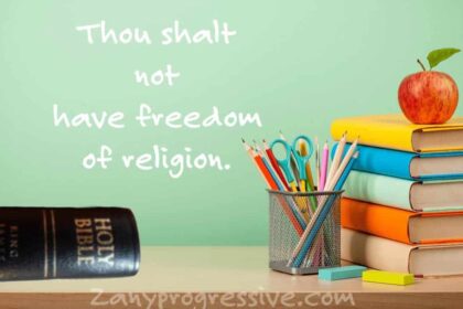 Teachers desk at school with a Bible on it and on the chalkboard behind it i