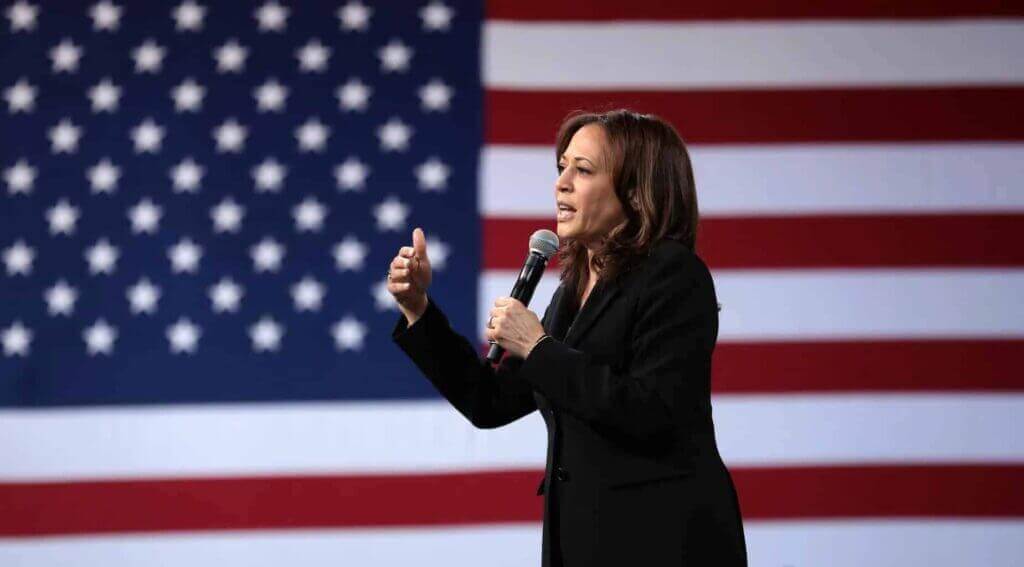 Kamala Harris speaking in front of the American flag