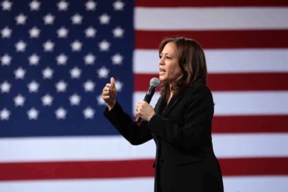 Kamala Harris speaking in front of the American flag