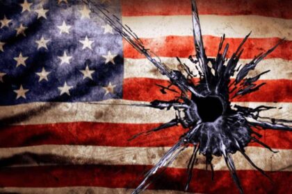 Image of the American flag with a bullet hole in it