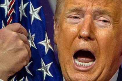 Closeup of Trump's face as he hugs the American flag