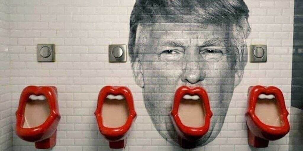 Trump's face painted on the wall behind a urinal so it looks like his mouth