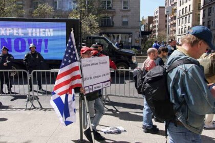 Protests in and around Columbia University in support of Palestine and against Israeli occupation. A pro-Israel demonstrator is in a less-populated area holding a sign saying "Hamas lovers go home. Iran is waiting for you. So is Sharia Law!" In the background is a different LED truck with a simple message: "Expel them now!"