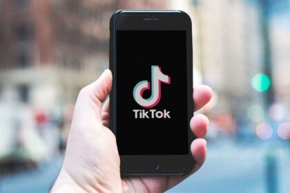 Hand holding a cell phone with the TikTok logo on it