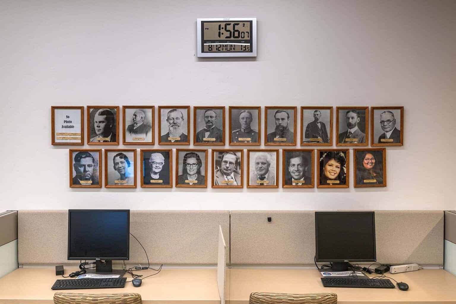A wall displays framed portraits of pima county recorders, including cázares-kelly, at her offices.