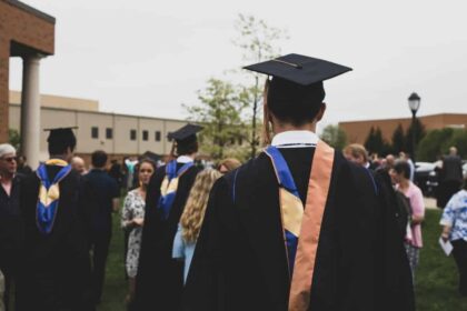 College students in their graduation gowns and caps among ceremony guests