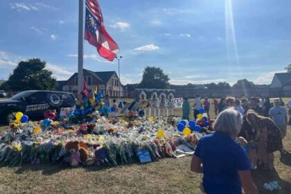 Community members and students gather around a flagpole on the Apalachee High School campus near Winder, Georgia, on Sept. 8, leaving flowers and messages to memorialize the four people killed in the Sept. 4 shooting there.