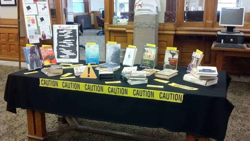 A banned book display in a library with police caution tape around the table