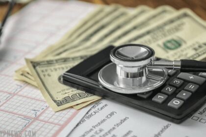 Medical debt: ekg, calculator and a stethoscope on cash