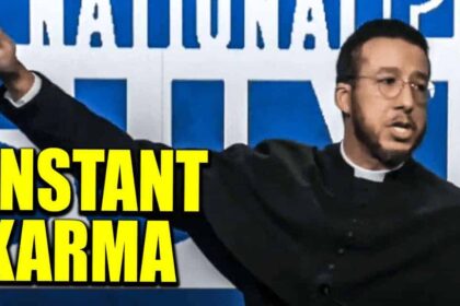 A priest wearing the long black robe doing the nazi salute on stage