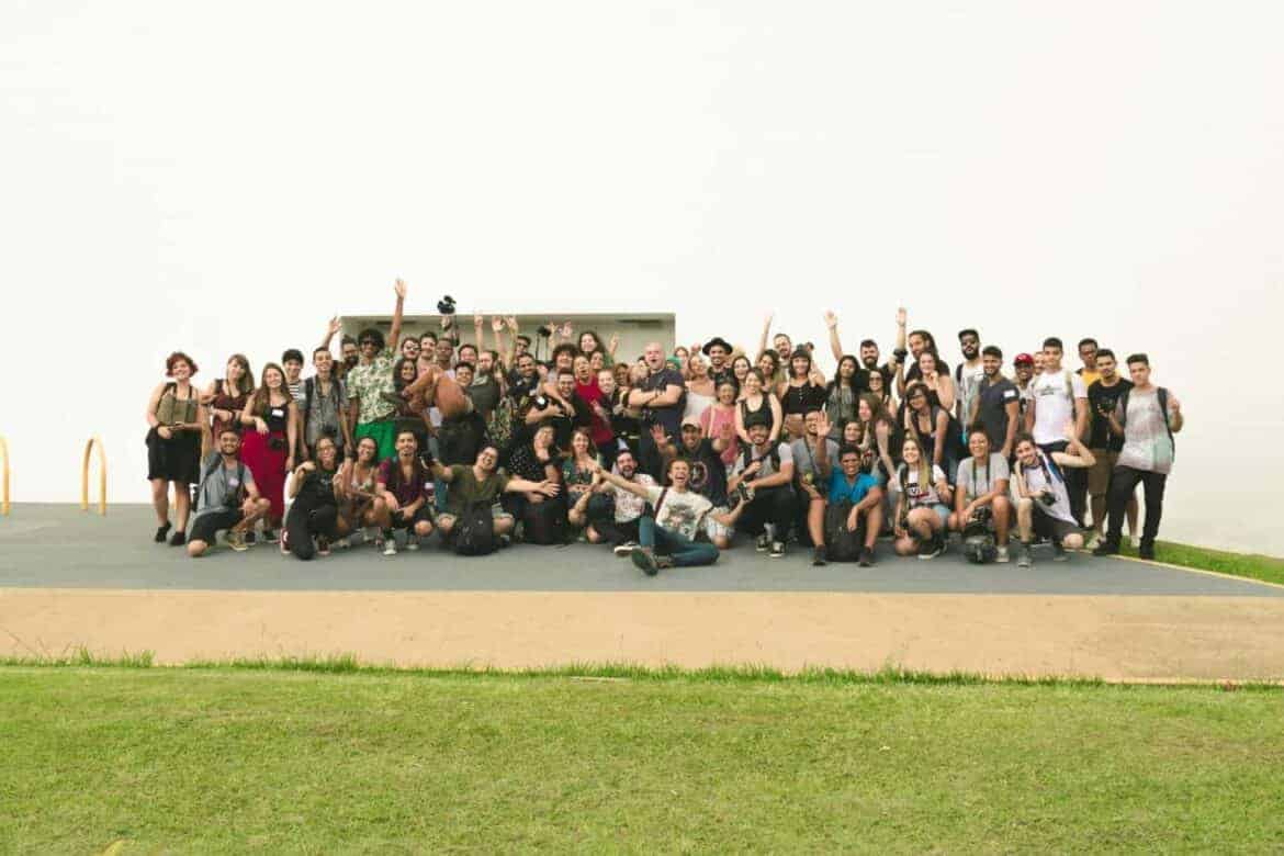 A joyful group of diverse friends celebrating outdoors on a sunny day.
