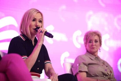 Pastor Paula White speaks on stage with Linda McMahon.