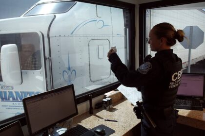 A U.S. Customs and Border Protection officer checks the identification of truck driver as he passes through the U.S. checkpoint of the Cargo Pre-Inspection at the Otay Mesa, Calif., port of entry, June 22, 2016. On any given day, several hundred trucks line up on the Mexican side of the border to deliver imports ultimately awaiting the process of screening by customs officers.