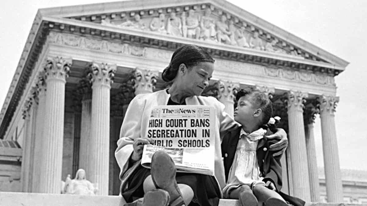 Authoritarian power grab. Mother and daughter sitting on steps in front of scotus, mother holds a newspaper with headline about segregation