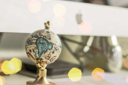 Close-up of a miniature globe on an office desk with a bokeh light effect, creating a dreamy atmosphere.