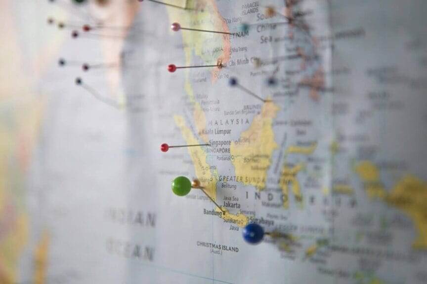 Isolationism. A map of the world on a wall with pins in it.