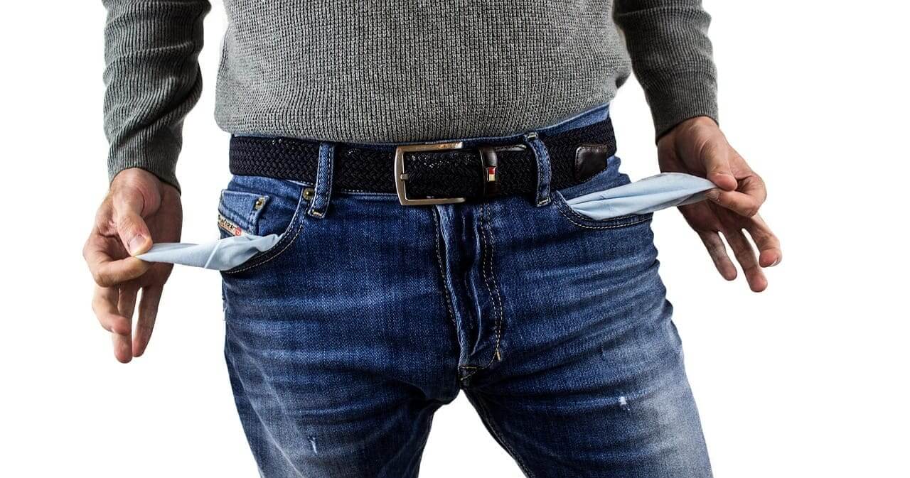 A man with empty jean pockets pulled inside out