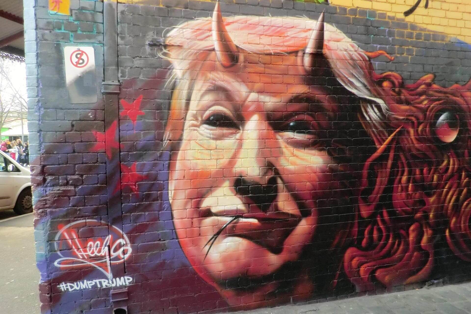 Donald trump is a fascist. Graffiti of trump as a snake with devil horns on a wall