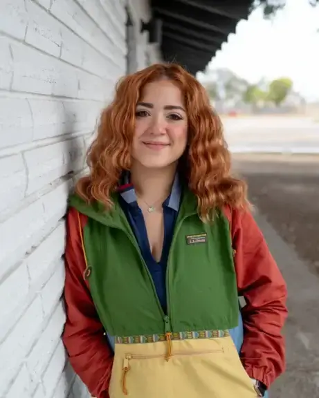border town community organizer Community organizer with long red hair and colorful clothing says the community needs resources, not border security.