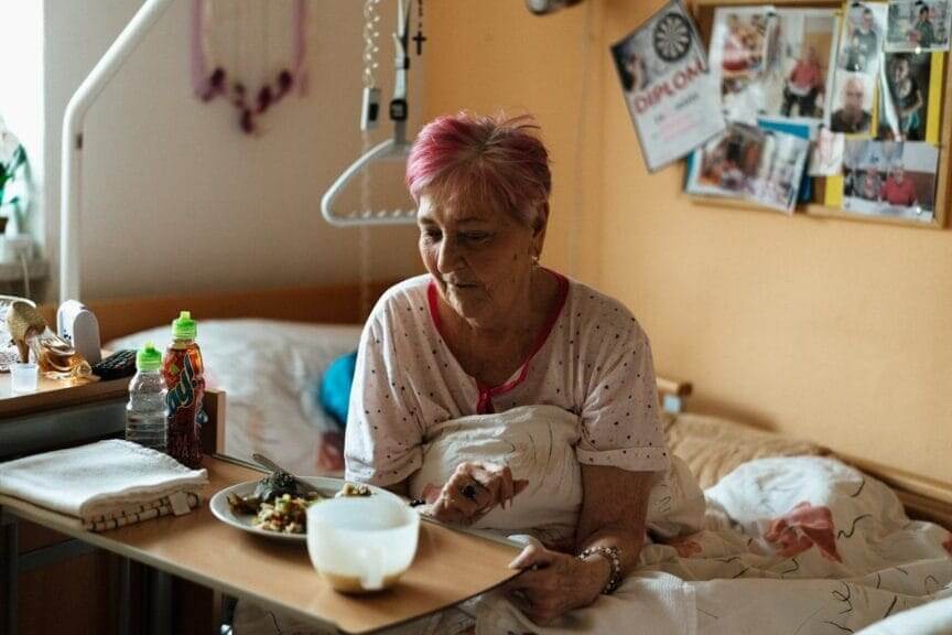 Older woman eating a meals on wheels meal