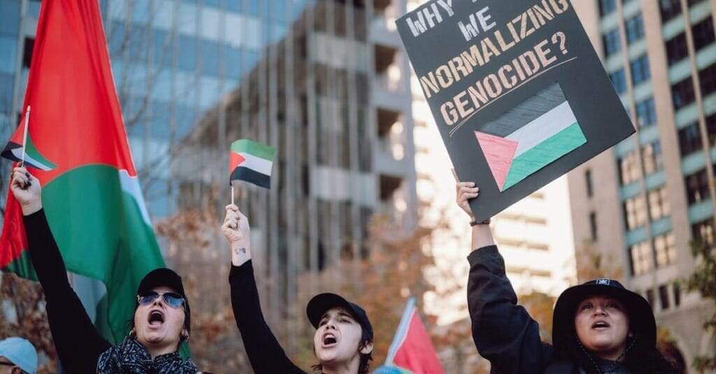 Belonging a protest scene with palestinian flags and banners advocating for peace and against genocide.