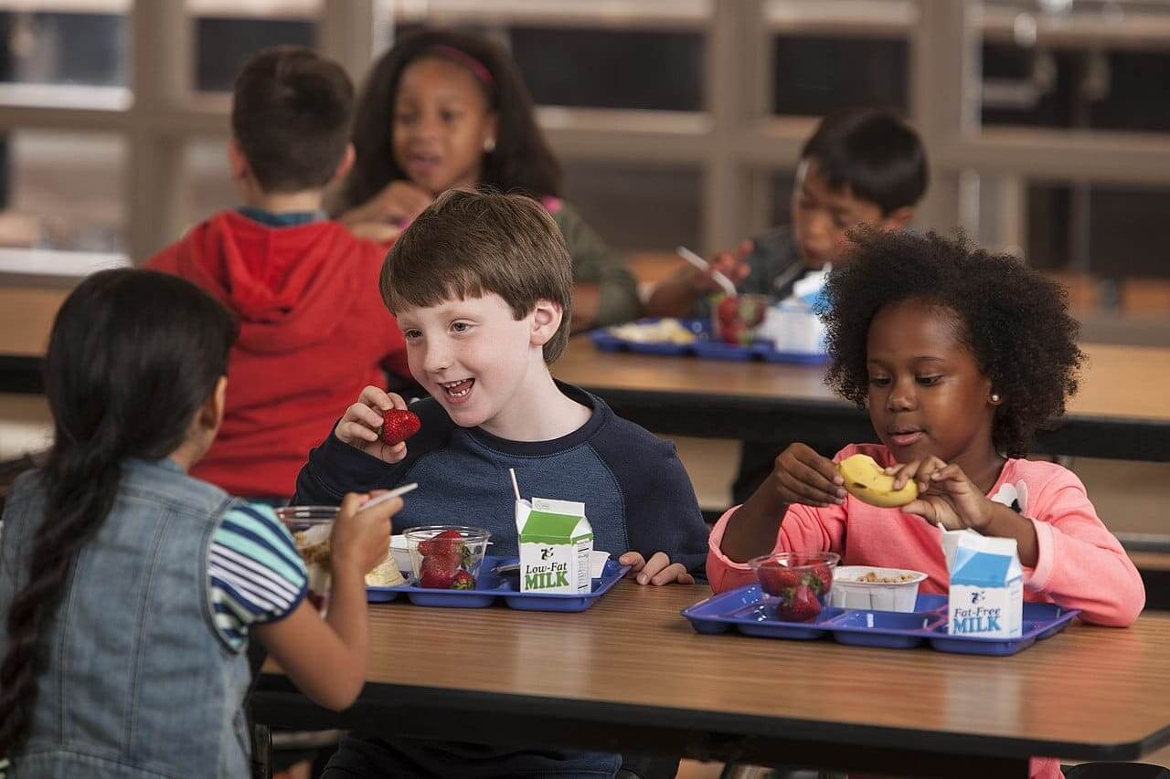 USDA cuts affect school meals. Elementary school students eat breakfast in the cafeteria