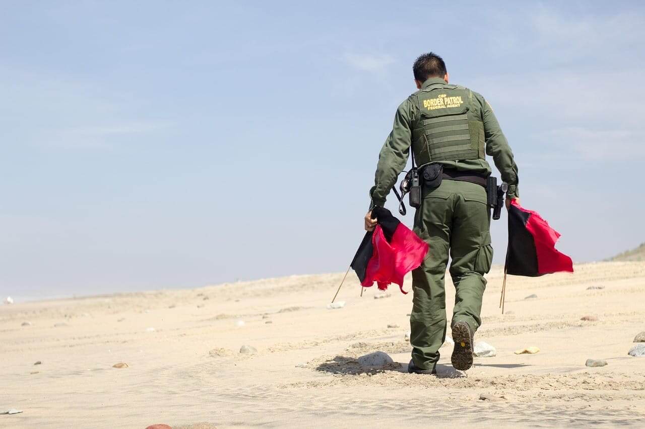 Border patrol agent picking up flags