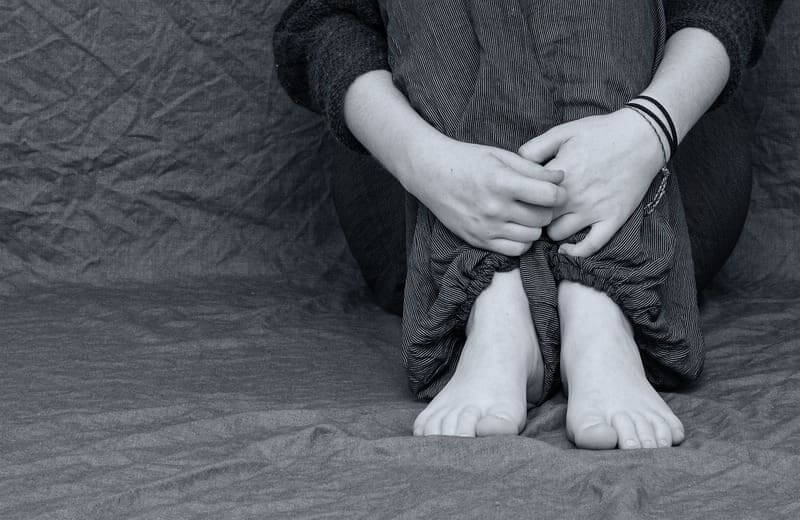 Ketamine treats people with major depressive disorder like this person, sitting on the floor with arms wrapped around their knees.