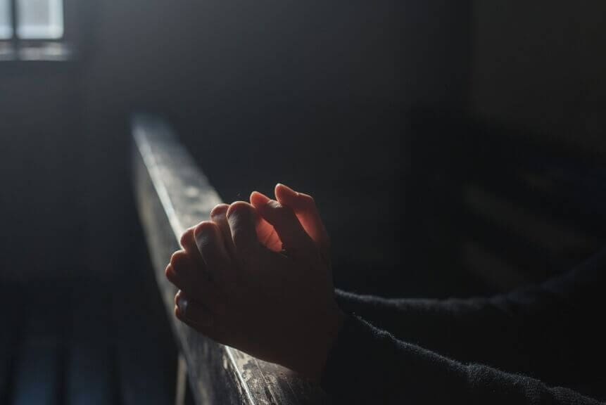 Hands in prayer at a church religious charter school
