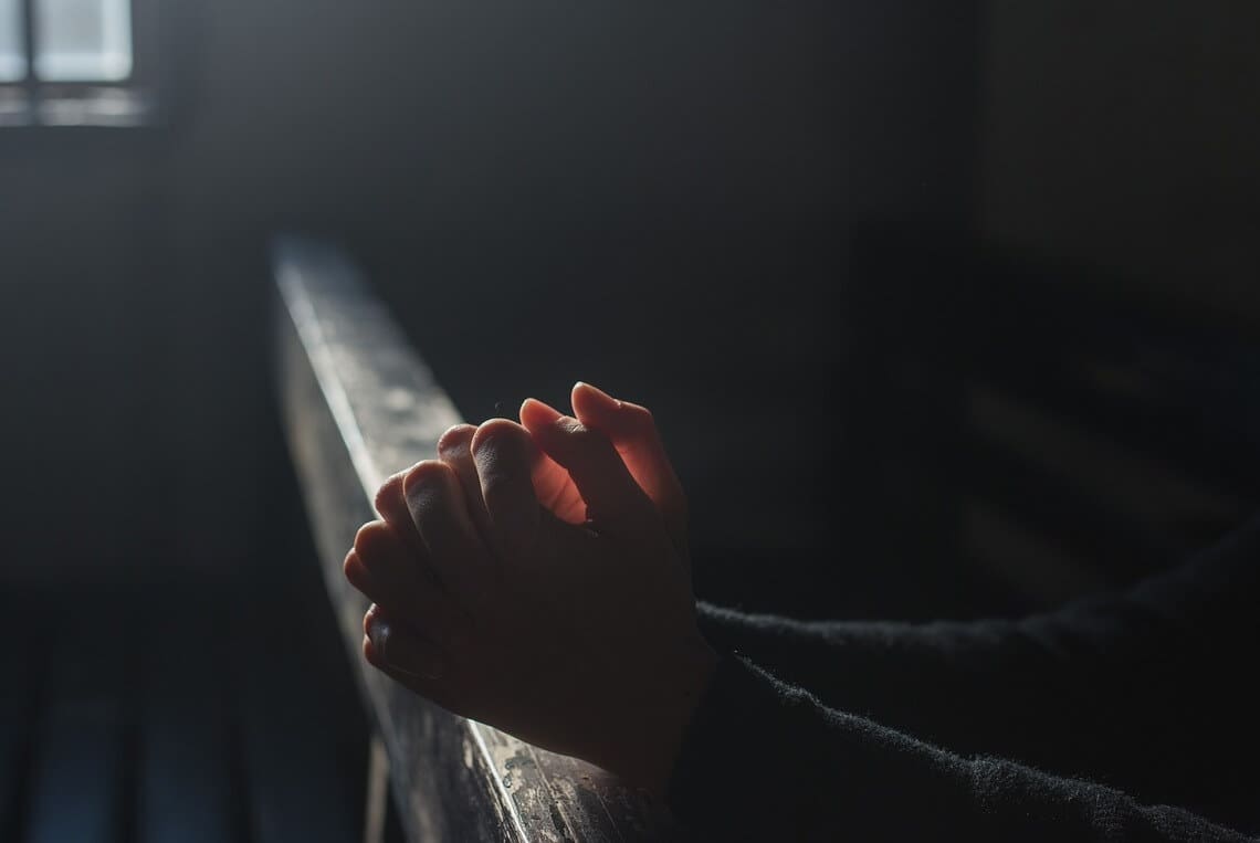 Hands in prayer at a church religious charter school