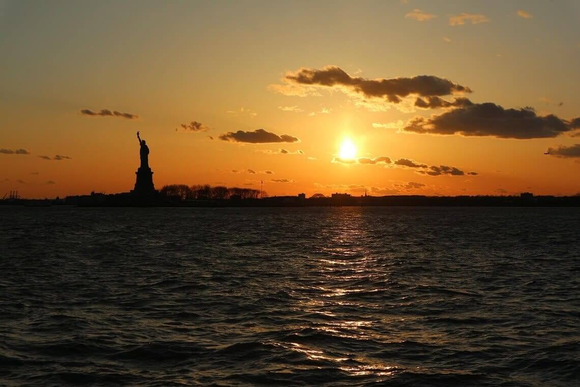 Midwest population buoyed by immigrants. Statue of liberty at sunset