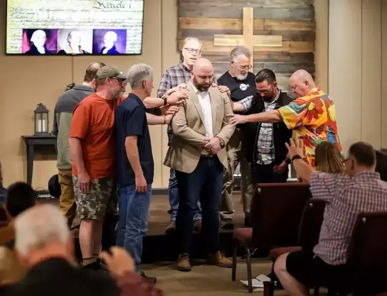 A group prays over Idaho Family Policy Center 