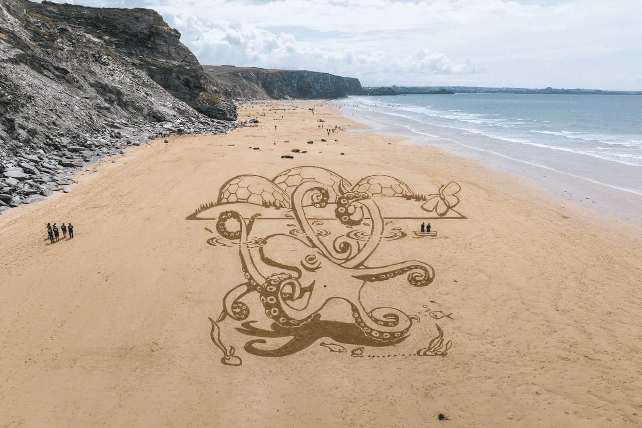 Giant octopus drawn in the sand on a beach