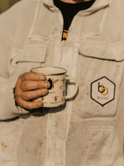 Woman who rescues bees holding a branded coffee mug