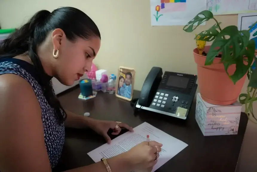 Katerin edits her schoolwork in her Houston office on Aug. 17, 2025. She works full-time as a case worker while also balancing a masters program in social work.