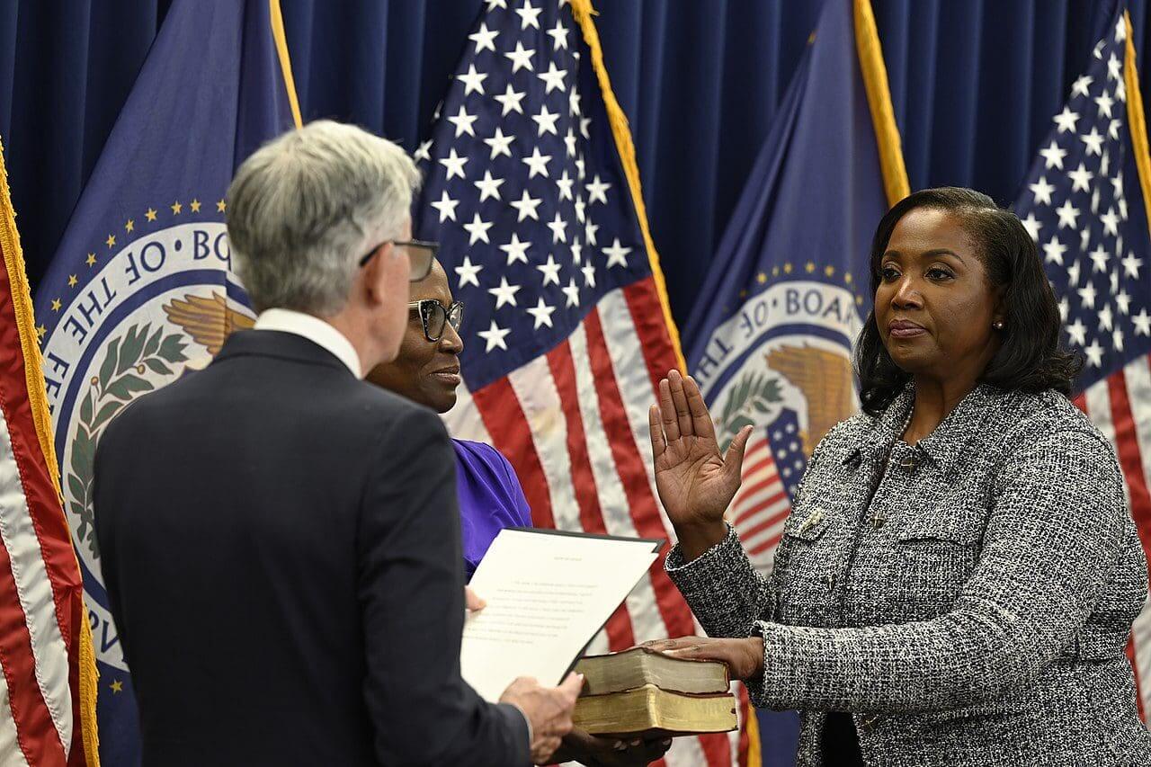 Lisa cook being sworn in by the federal reserve chair jerome powell