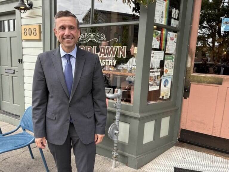 Dnc chair ken martin standing outside a coffee ship, smiling