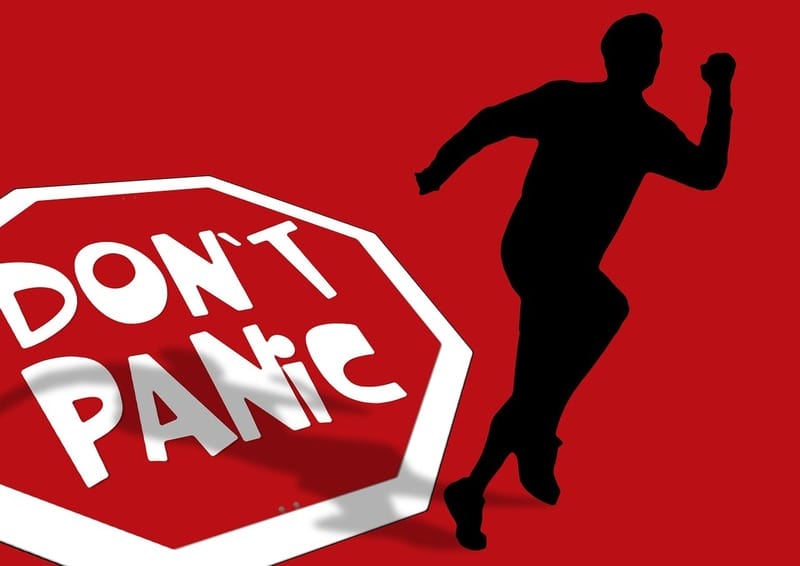 Don’t panic sign and silhouette of a person running.