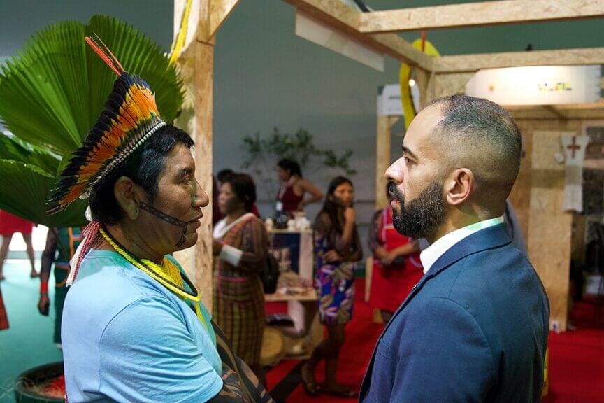 An indigenous man speaking with a member of dpu in brazil
