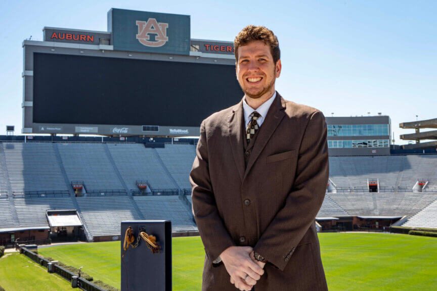 Man wearing a suit standing in a football stadium