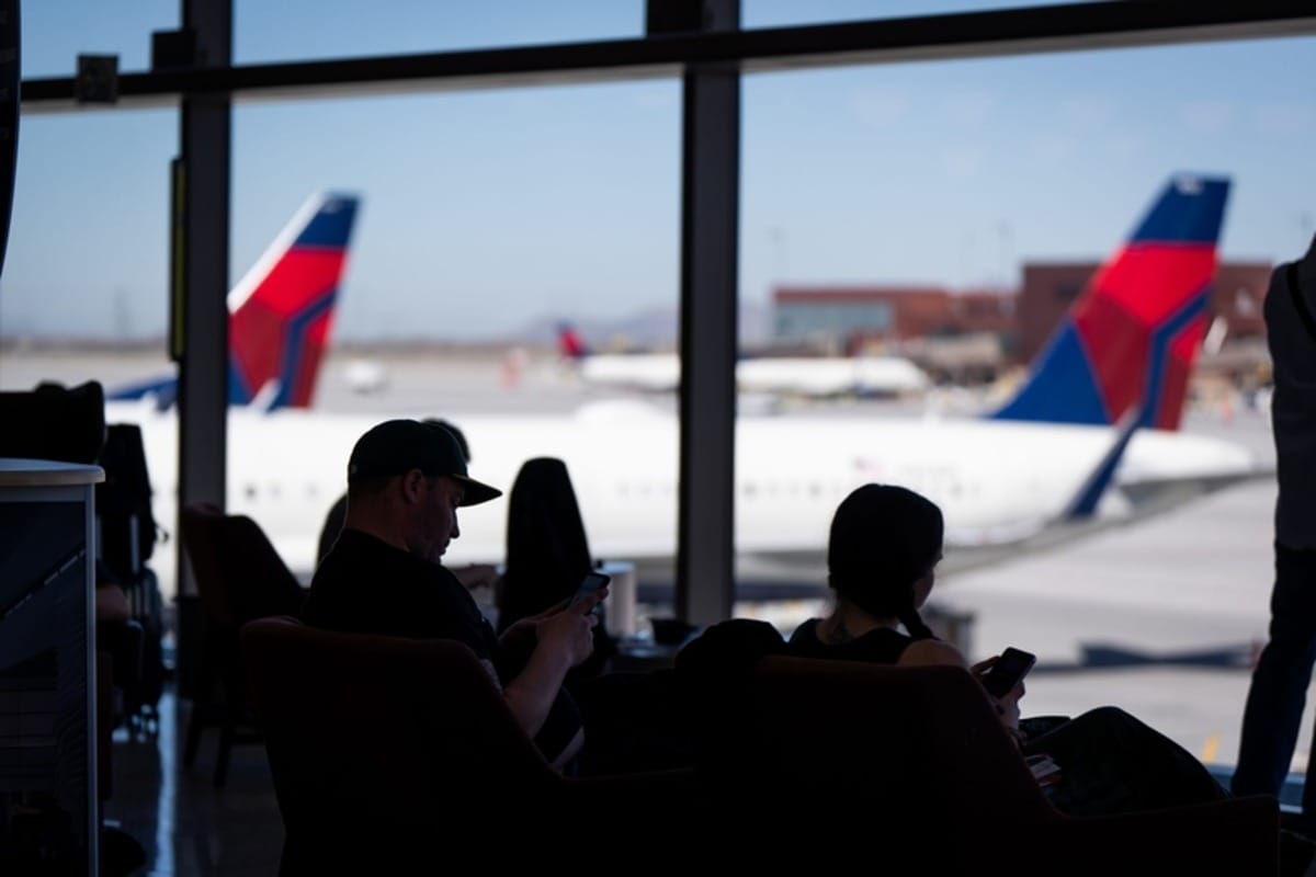 People sitting in an airport waiting for their flight.