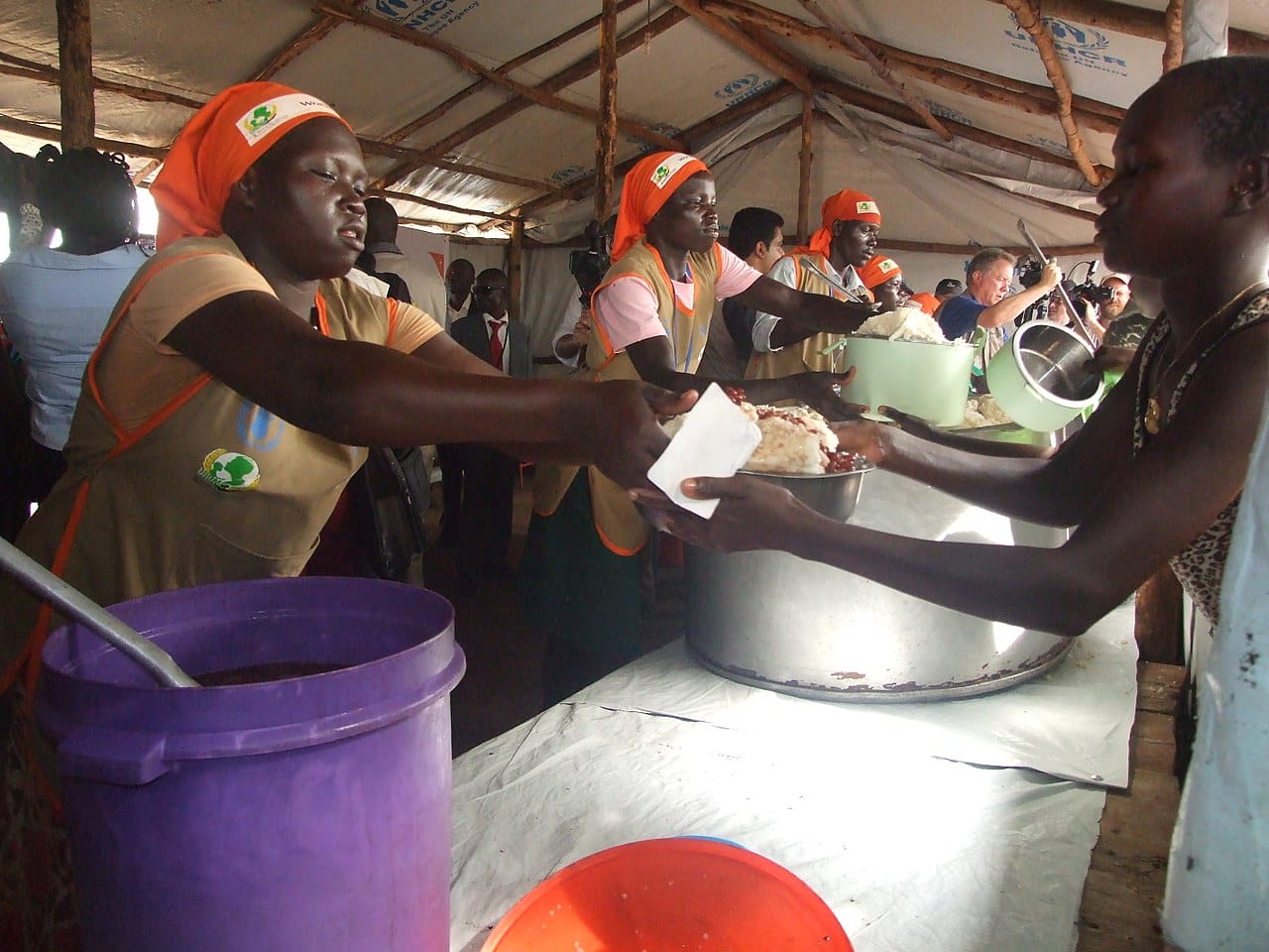 Refugees from south sudan being served food.