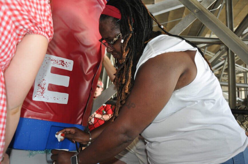 Woman getting water from a cooling station in a football stadium