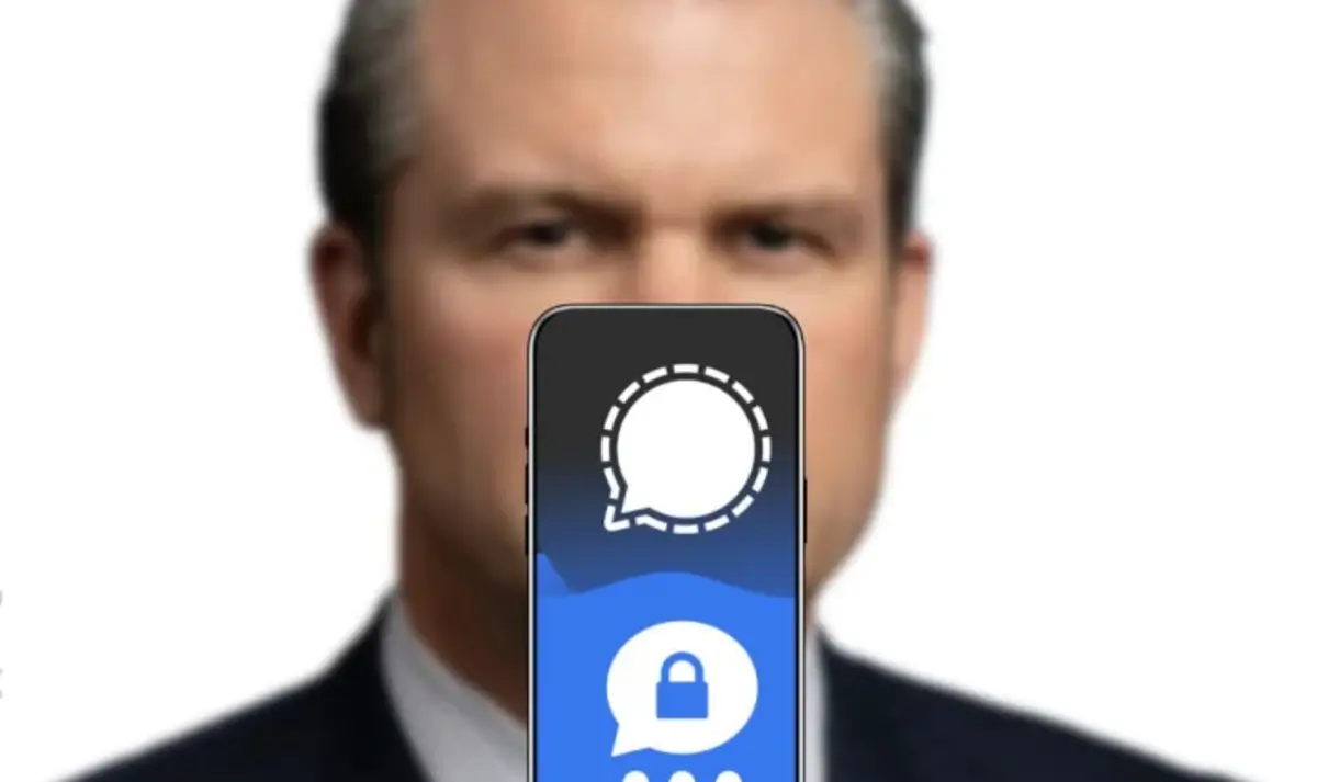 Pete hegseth blurry with a cell phone displaying the signal app logo in front of him